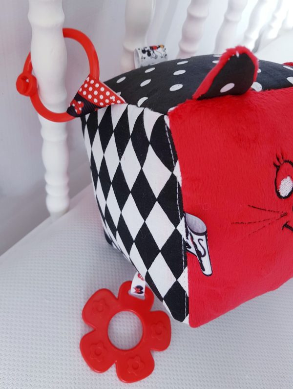 Duża kontrastowa kostka sensoryczna uszyta z bawełny w kontrastowych kolorach czarno - biało - czerwonych. Na jednym z boków haft buźki kotka i uszka. 